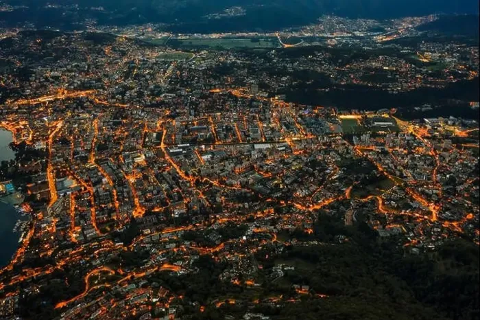 Framed Print : High angle aerial drone shot view Lugano by lake with city street lights after sunset in Switzerland Framed Print : High angle aerial drone shot view Lugano by lake with city street lights after sunset in Switzerland
