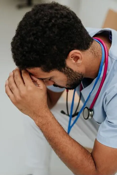 Framed Print : High angle view of tired doctor, sitting at hospital corridor Framed Print : High angle view of tired doctor, sitting at hospital corridor