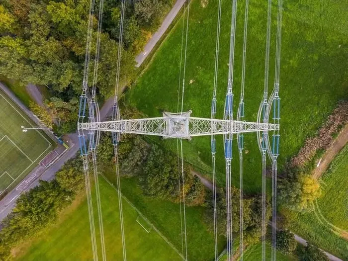 Framed Print : High voltage pylon with power lines between nature and sports field photographed directly from above with drone Framed Print : High voltage pylon with power lines between nature and sports field photographed directly from above with drone