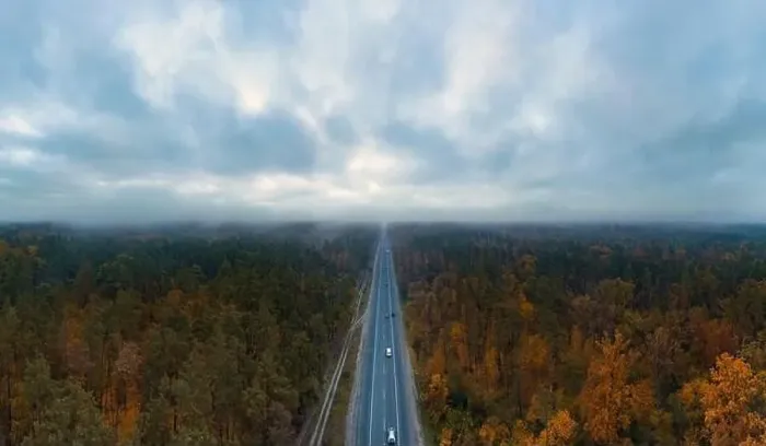 Framed Print : Highway road with passing cars in autumn forest with dark moody sky with clouds from aerial view Framed Print : Highway road with passing cars in autumn forest with dark moody sky with clouds from aerial view
