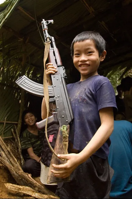 Framed Print : Hmong boy hold AK 47 while hiding in the jungles of Laos Framed Print : Hmong boy hold AK 47 while hiding in the jungles of Laos
