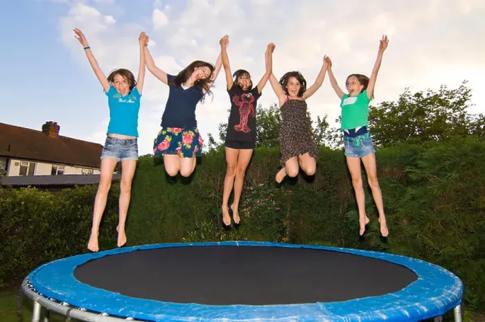 Framed Print : Horizontal close up portrait of a group of girl friends jumping on a trampoline in a garden Framed Print : Horizontal close up portrait of a group of girl friends jumping on a trampoline in a garden