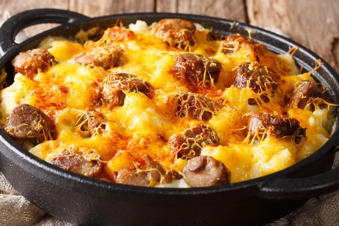 Framed Print : Hot Jolean's potato casserole, smoked sausages with cheese sauce close-up in a frying pan on the table. horizontal Framed Print : Hot Jolean's potato casserole, smoked sausages with cheese sauce close-up in a frying pan on the table. horizontal