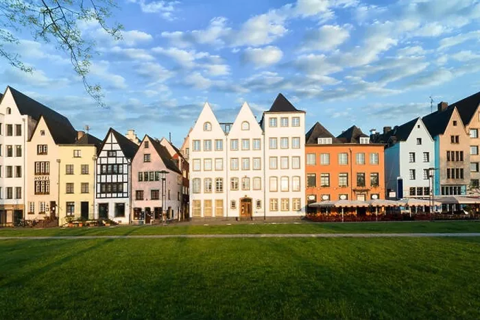 Framed Print : Houses and park in Cologne, Germany. Many of them are colourful, they are facing a public park with green grass and some trees. There is a Cologne bel Framed Print : Houses and park in Cologne, Germany. Many of them are colourful, they are facing a public park with green grass and some trees. There is a Cologne bel
