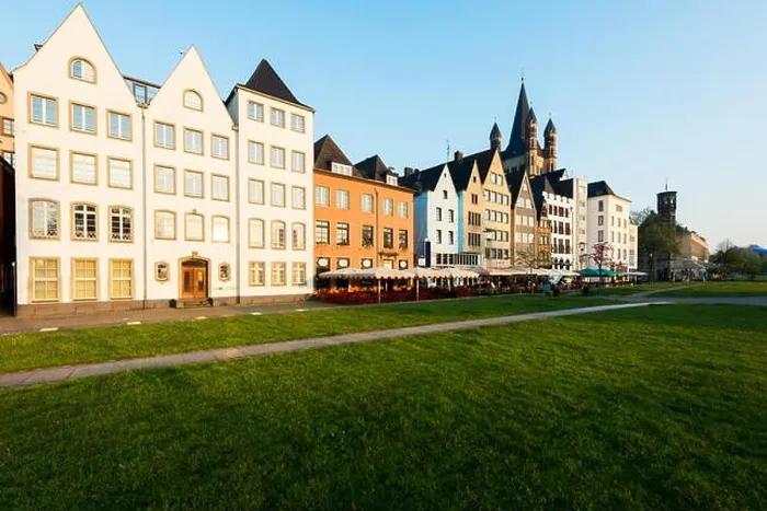 Framed Print : Houses and park in Cologne, Germany. Many of them are colourful, they are facing a public park with green grass and some trees. There is a Cologne bel Framed Print : Houses and park in Cologne, Germany. Many of them are colourful, they are facing a public park with green grass and some trees. There is a Cologne bel