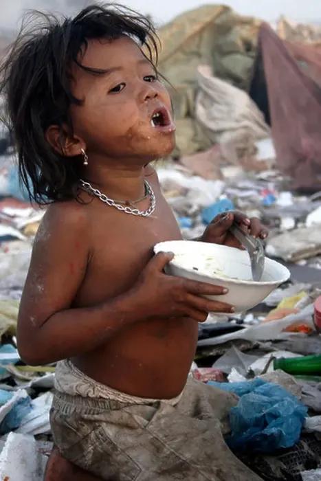 Framed Print : A hungry young child worker satisfies her hunger by eating a meal at The Stung Meanchey Landfill in Phnom Penh Framed Print : A hungry young child worker satisfies her hunger by eating a meal at The Stung Meanchey Landfill in Phnom Penh