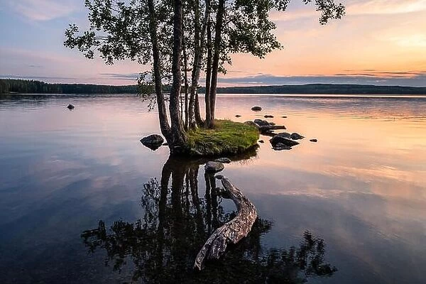 Idyllic smalll island with tranquil lake and beautiful sunset at summer evening in Finland