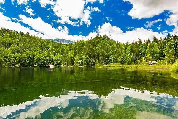 Idyllic summer landscape with clear mountain lake in the Alps. Tranquil nature landscape in the Alps, Europe. Water reflection, blue sky, pine forest