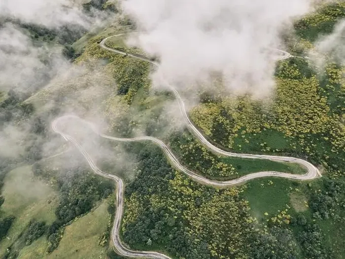 Framed Print : image taken with a drone of a long road with many curves on the slope of the green mountain between grassy vegetation Framed Print : image taken with a drone of a long road with many curves on the slope of the green mountain between grassy vegetation
