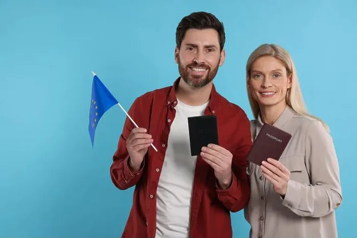 Framed Print : Immigration. Happy couple with passports and flag of European Union on light blue background Framed Print : Immigration. Happy couple with passports and flag of European Union on light blue background