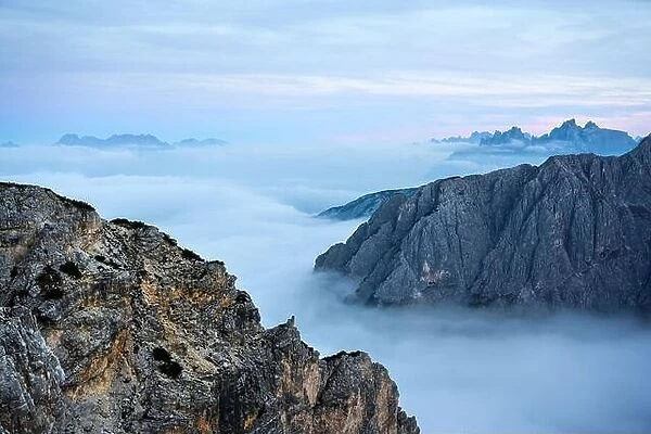 Incredible sunrise landscape with flowing fog and dramatic skies in the Dolomites mountains
