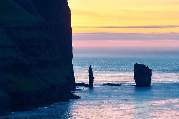 Incredible sunrise morning view on Risin og Kellingin cliffs in Atlantic ocean, Eysturoy island, Faroe Islands, Denmark. Landscape photography