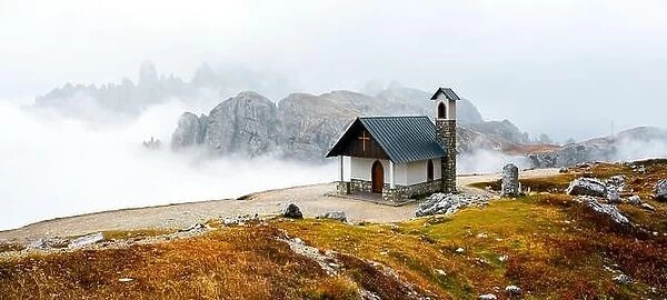 Incredible view on small chapel in the Tre Cime Di Laveredo National Park in morning fog. Dolomite Alps mountains, Trentino Alto Adige region
