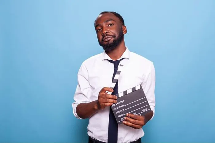 Framed Print : Independent successful filmmaker holding open clapper in hands looking confident with head tilted Framed Print : Independent successful filmmaker holding open clapper in hands looking confident with head tilted