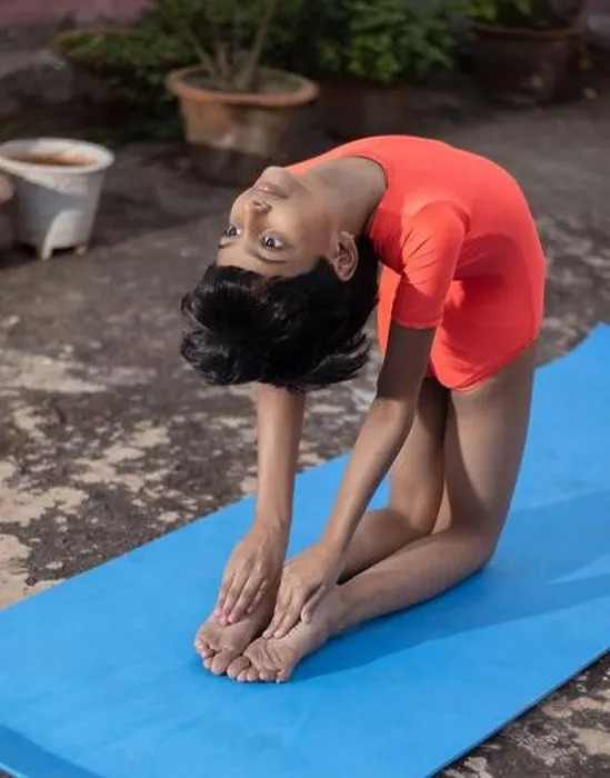 Framed Print : An Indian girl child practicing Ustrasana yoga on yoga mat outdoors Framed Print : An Indian girl child practicing Ustrasana yoga on yoga mat outdoors