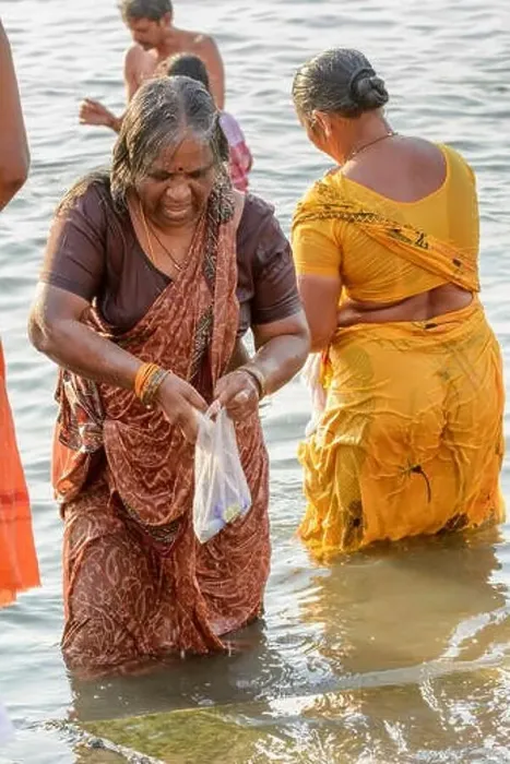 Framed Print : An Indian Hindu woman wearing a sari performs an early morning bathing ritual in the River Ganges in Varanasi