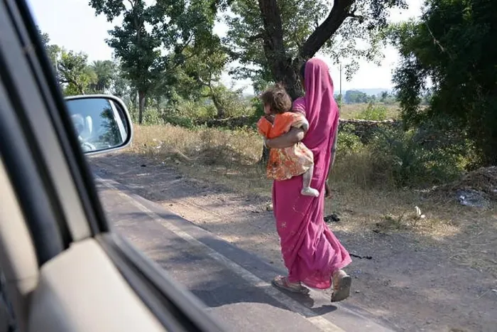 Framed Print : Indian local woman with child, walking at the roadside in india Framed Print : Indian local woman with child, walking at the roadside in india
