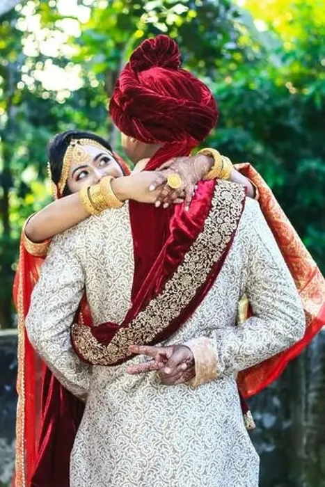 Framed Print : Indian wedding couple hugging and groom showing victory sign with green bokeh background Framed Print : Indian wedding couple hugging and groom showing victory sign with green bokeh background