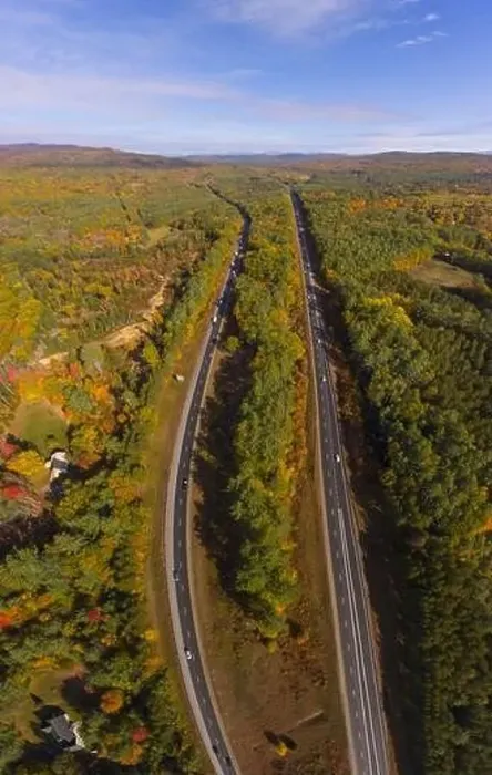 Framed Print : Interstate Highway 93 at Exit 22 with NH Route 127 in White Mountain National Forest aerial view with fall foliage
