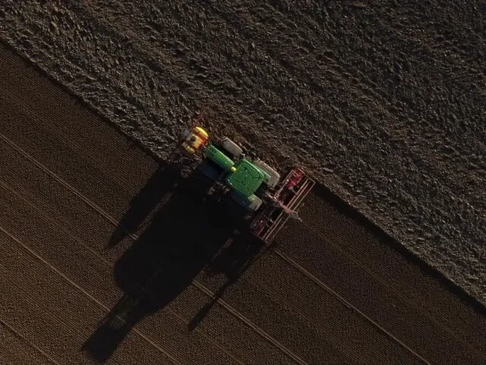 Framed Print : A John Deere Tractor seeds a previously cultivated field with sweetcorn, late in the evening