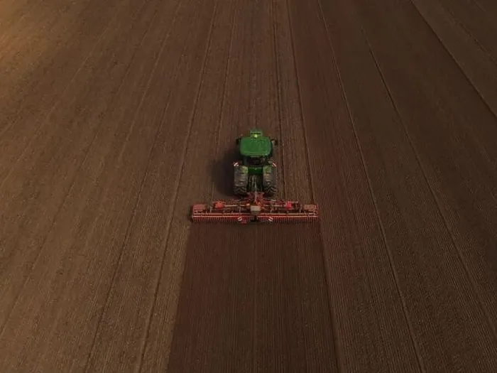 Framed Print : A John Deere tractor, seen from above, cultivates a field in preparation for planting Framed Print : A John Deere tractor, seen from above, cultivates a field in preparation for planting