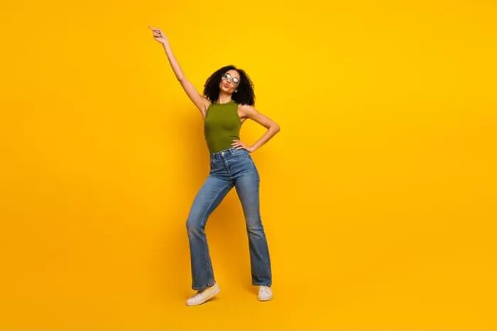 Framed Print : Joyful young woman in trendy outfit posing against bright yellow background with confident energy Framed Print : Joyful young woman in trendy outfit posing against bright yellow background with confident energy