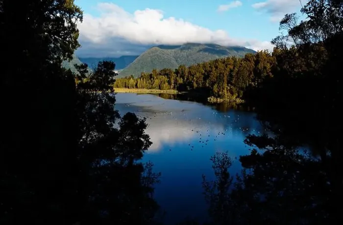 Framed Print : Lake Matheson is nestled in ancient forest and is famous for mirror views of Aoraki / Mount Cook and Mount Tasman Framed Print : Lake Matheson is nestled in ancient forest and is famous for mirror views of Aoraki / Mount Cook and Mount Tasman