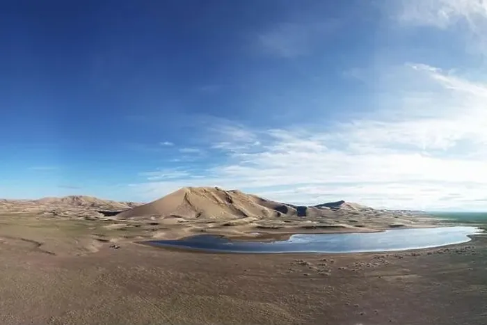 Framed Print : A large lake on the edge of a sandy desert. Mongolia sandy dune desert Mongol Els. Khovd province, Western Mongolia
