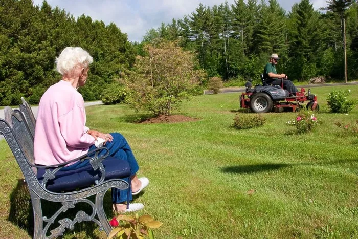 Framed Print : Lawn care service mowing elderly woman's lawn while she watches Framed Print : Lawn care service mowing elderly woman's lawn while she watches
