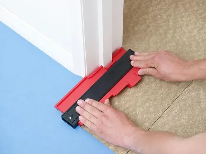 Framed Print : Laying vinyl tile floor, cutting around a corner Framed Print : Laying vinyl tile floor, cutting around a corner