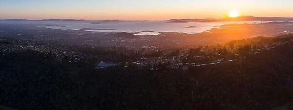 The last light of day illuminates San Francisco Bay and its surrounding cities and hills. This area is bordered by open space in the East Bay