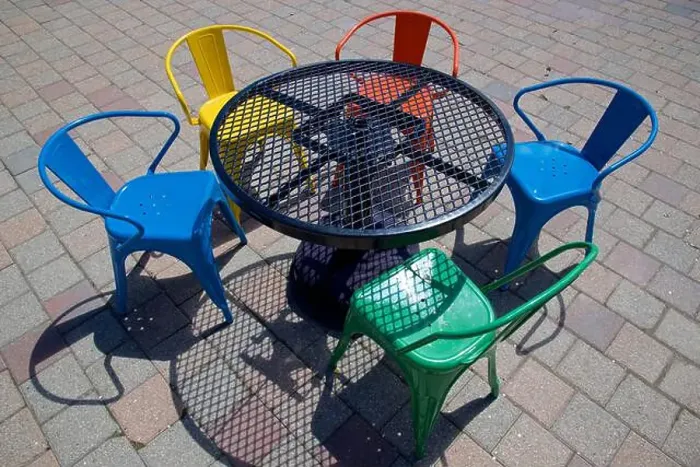 Framed Print : Light and shadow of the multi coloured chairs and table Framed Print : Light and shadow of the multi coloured chairs and table