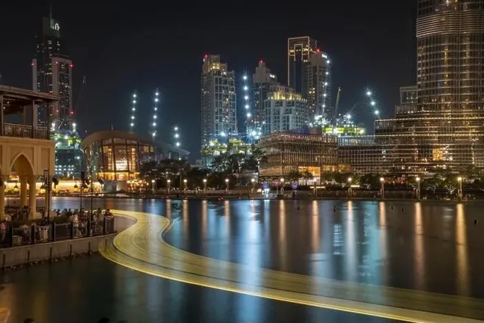 Framed Print : The lights of an abra boat wind past the Opera House and directly beneath the world's tallest building in Dubai Framed Print : The lights of an abra boat wind past the Opera House and directly beneath the world's tallest building in Dubai