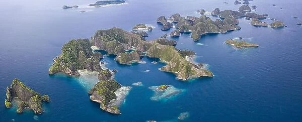 Limestone islands lie scattered about the seascape in Raja Ampat, Indonesia. This remote, tropical region is known for its marine biodiversity