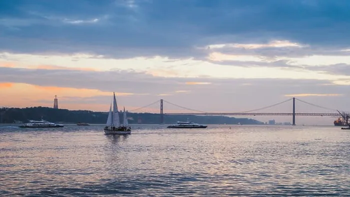 Framed Print : Lisbon, Portugal - Oct 23, 2018: Sunset on River Tagus, Lisbon, Portugal with 25 April Bridge in background and boats Framed Print : Lisbon, Portugal - Oct 23, 2018: Sunset on River Tagus, Lisbon, Portugal with 25 April Bridge in background and boats