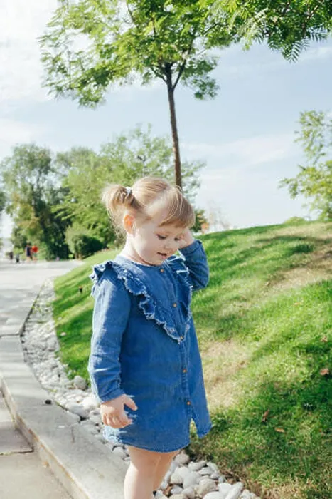 Framed Print : Little 3 years old girl in a blue jeans dress walking in a park on a warm sunny day Framed Print : Little 3 years old girl in a blue jeans dress walking in a park on a warm sunny day