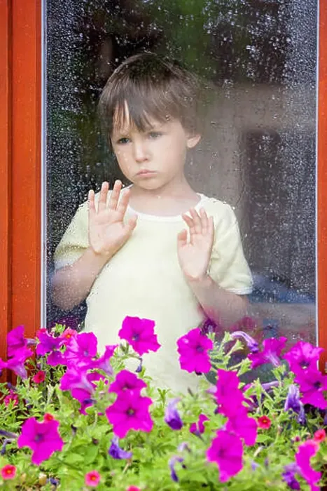 Framed Print : Little boy behind the window in the rain, looking sad Framed Print : Little boy behind the window in the rain, looking sad