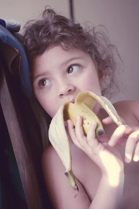Framed Print : Little girl eating banana Framed Print : Little girl eating banana
