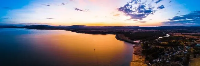 Framed Print : Lonely boat sailing across scenic lake at vivid orange sunset - aerial panorama Framed Print : Lonely boat sailing across scenic lake at vivid orange sunset - aerial panorama