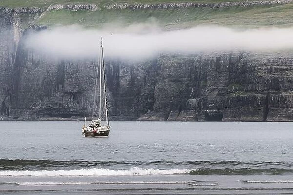 Lonely yacht near Tjornuvik coast on Streymoy Island, Faroe Islands. Landscape photography