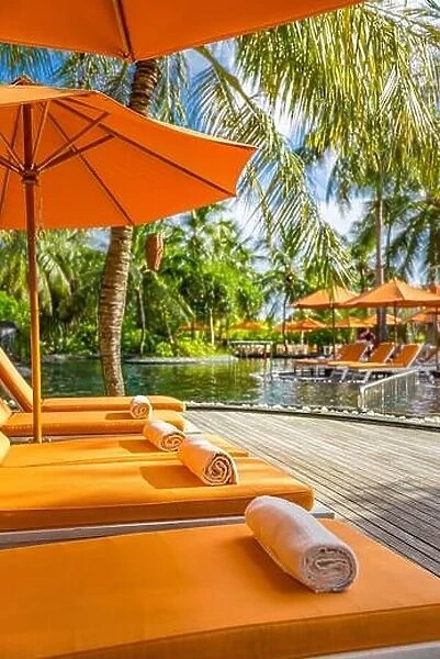 Luxurious resort, tropical poolside, infinity swimming pool with orange loungers and umbrellas under palm trees. Summer vacation, holiday. Spa, fun