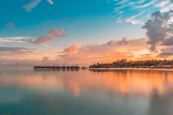 Luxury beach resort. Water villas on island shore, tropical bay lagoon. Sea reflection, peaceful sunset sunrise landscape. Paradise nature