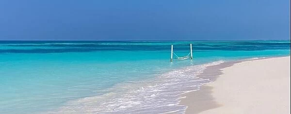 Luxury beach. Tranquil travel background. Summer vacation or holiday concept on tropical beach white sand and amazing over water hammock over blue bay