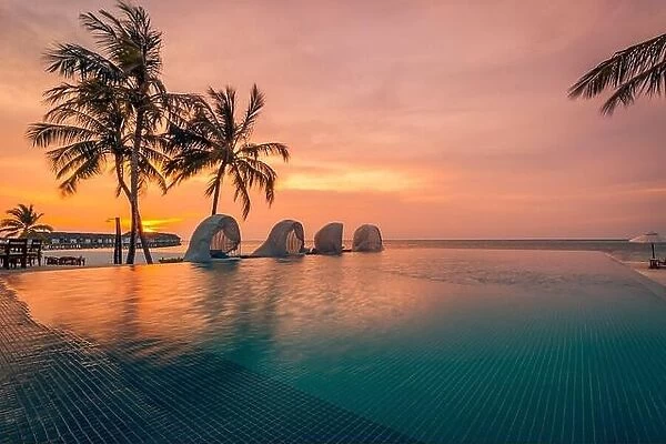 Luxury pool sunset, palm tree silhouette with windy infinity pool water surface. Summer vacation, holiday template. Stunning sky, beachfront resort