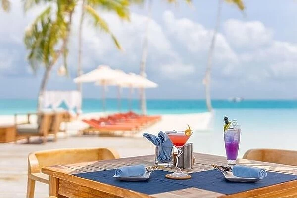 Luxury resort outdoor restaurant table with beach chairs, close to infinity pool on tropical landscape. Exotic summer vacation holiday background