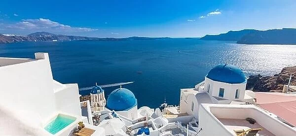 Luxury travel vacation. Oia town on Santorini island, Greece. Traditional and famous houses and churches with blue domes over the Caldera, Aegean sea