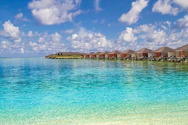 Luxury water bungalows and amazing blue sea in Maldives island. Paradise concept for summer vacation and holiday design