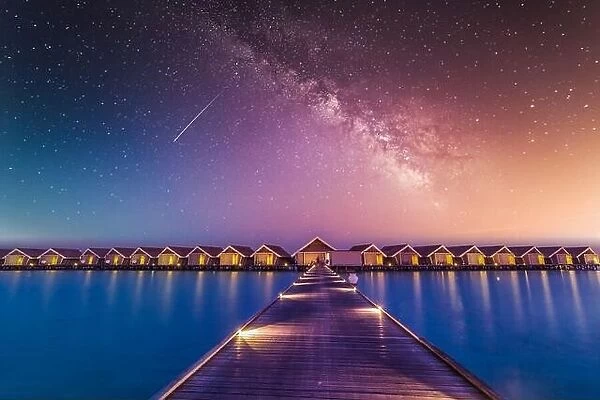 Luxury over water villas, bungalows sea ocean with beach at night sunset time, Milky Way. Exotic adventure carefree travel vacation, summer resort