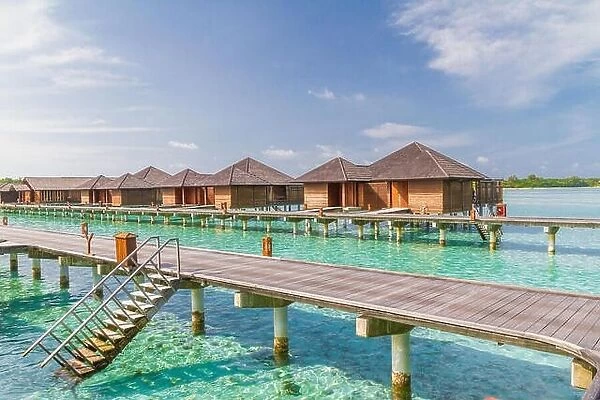 Luxury over water villas in Maldives, wooden jetty and blue lagoon