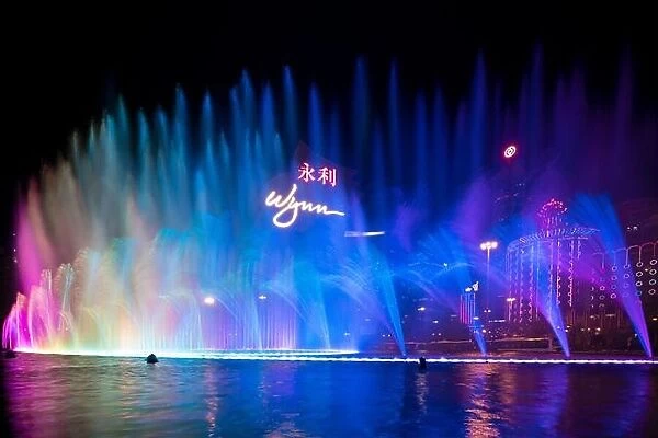 Macau, China - October 14, 2017 : Beautiful and very colorful city with lots of bright neon signs. Photo of the dancing fountain show at the famous Wy